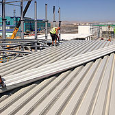 Montage der Dachtrapezbleche am Neubau der Produktionshalle in Baku